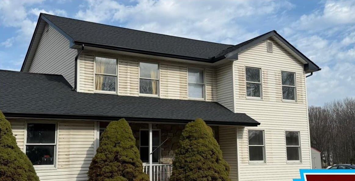 Before — Two-story vinyl-sided home, algae streaks soft washed away